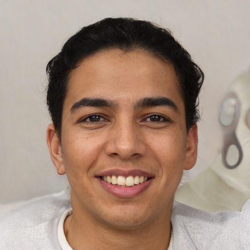 Joyful latino young-adult male with short  brown hair and brown eyes