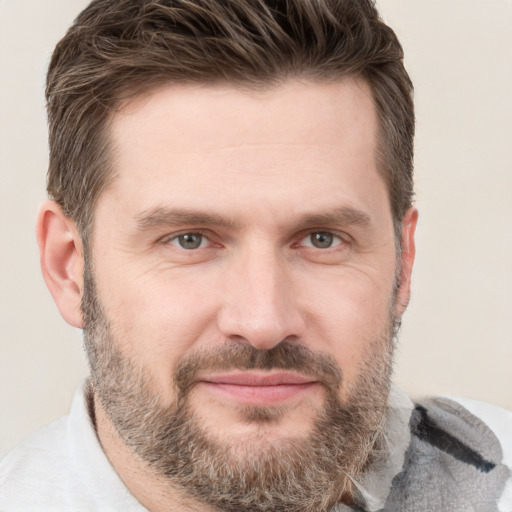 Joyful white adult male with short  brown hair and brown eyes