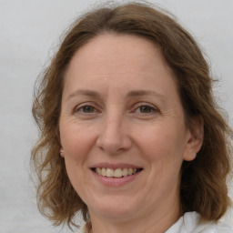 Joyful white adult female with medium  brown hair and blue eyes