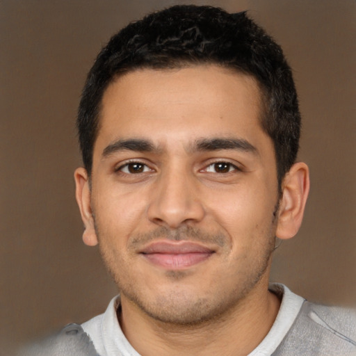 Joyful latino young-adult male with short  black hair and brown eyes