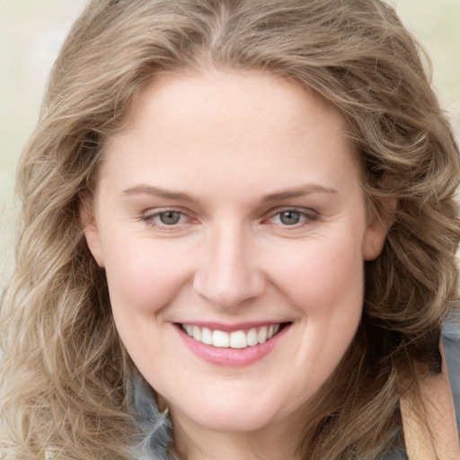 Joyful white young-adult female with long  brown hair and blue eyes