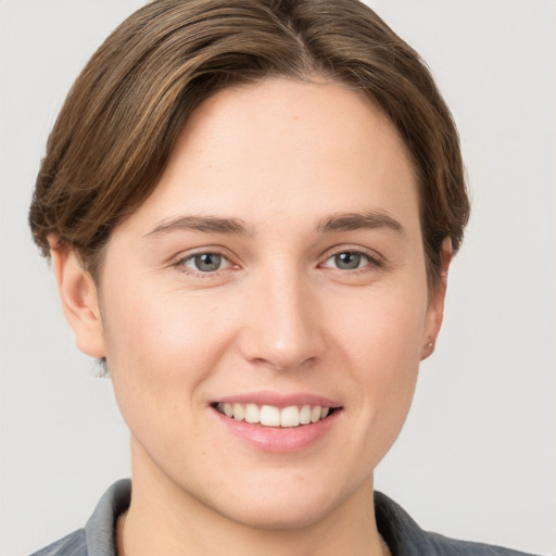 Joyful white young-adult female with short  brown hair and grey eyes