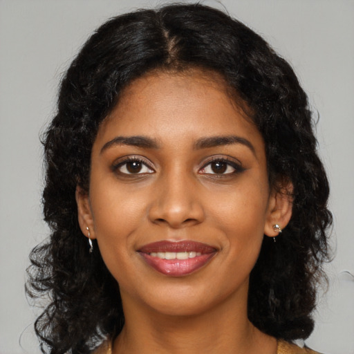 Joyful black young-adult female with long  black hair and brown eyes