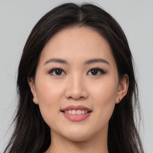 Joyful asian young-adult female with long  brown hair and brown eyes