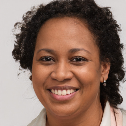 Joyful black adult female with long  brown hair and brown eyes