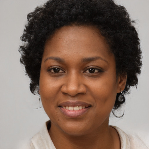 Joyful black adult female with short  brown hair and brown eyes