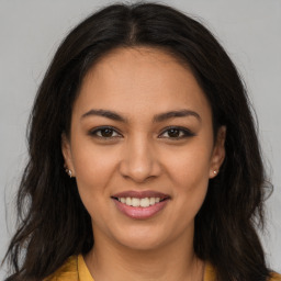 Joyful latino young-adult female with long  brown hair and brown eyes