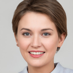 Joyful white young-adult female with short  brown hair and grey eyes