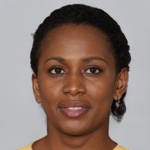 Joyful black young-adult female with short  black hair and brown eyes