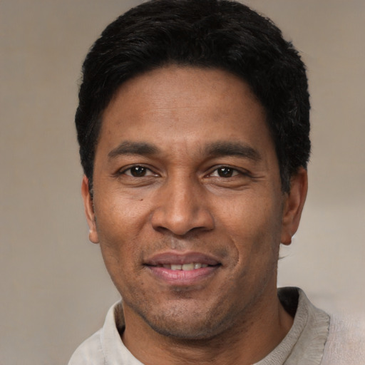 Joyful latino adult male with short  black hair and brown eyes