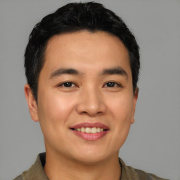 Joyful asian young-adult male with short  black hair and brown eyes