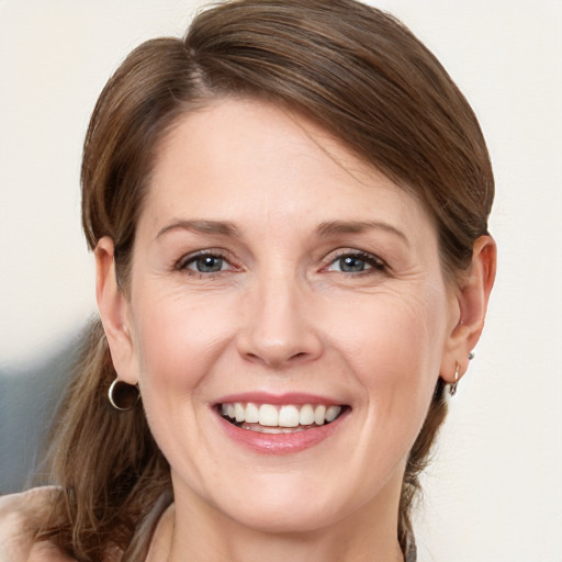 Joyful white young-adult female with medium  brown hair and grey eyes