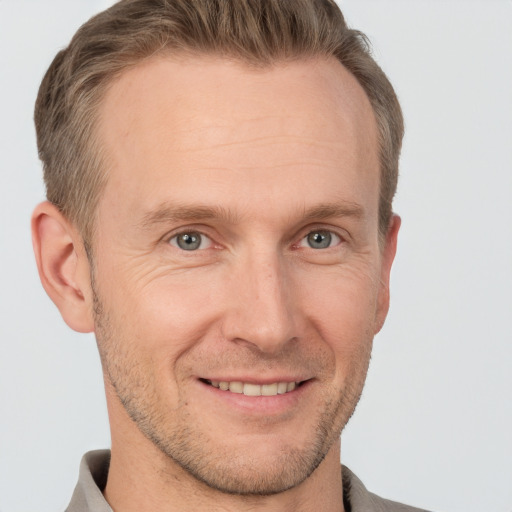 Joyful white adult male with short  brown hair and brown eyes