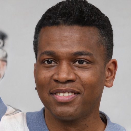 Joyful black young-adult male with short  black hair and brown eyes