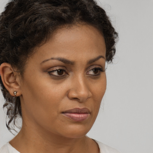 Joyful black young-adult female with medium  brown hair and brown eyes
