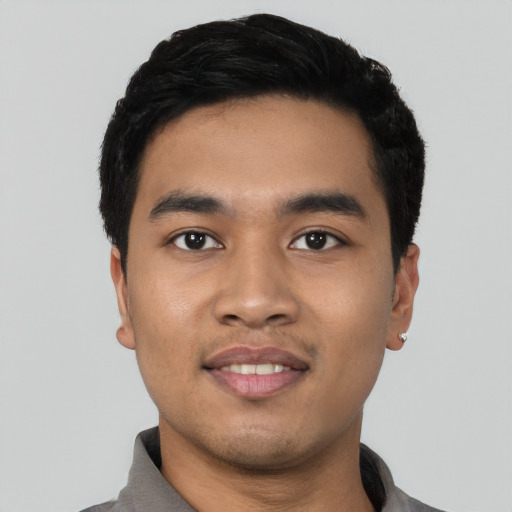 Joyful latino young-adult male with short  black hair and brown eyes