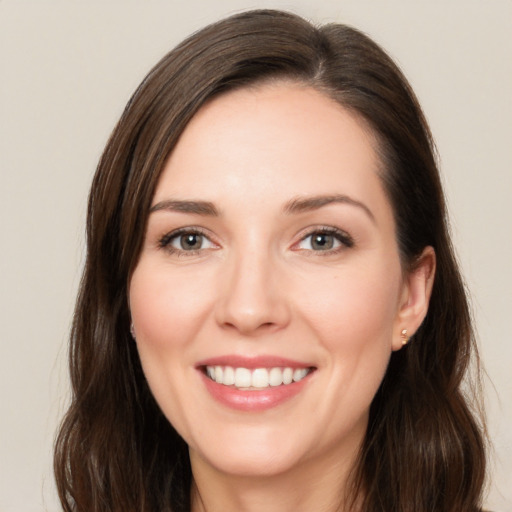 Joyful white young-adult female with long  brown hair and brown eyes