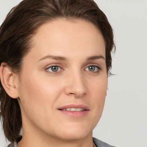 Joyful white young-adult female with medium  brown hair and grey eyes