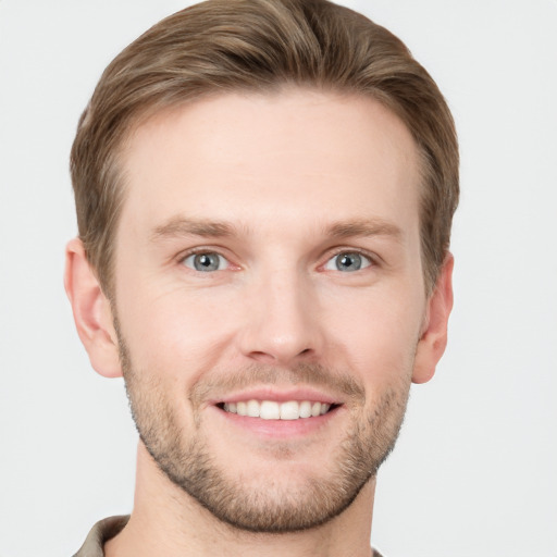 Joyful white young-adult male with short  brown hair and grey eyes