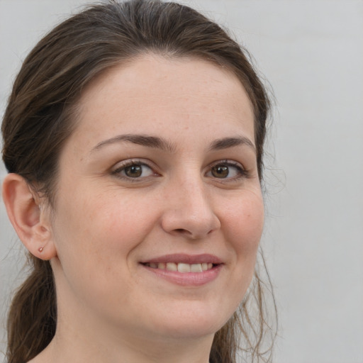 Joyful white young-adult female with medium  brown hair and grey eyes