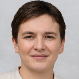 Joyful white young-adult male with short  brown hair and grey eyes