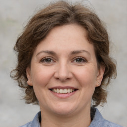 Joyful white adult female with medium  brown hair and grey eyes