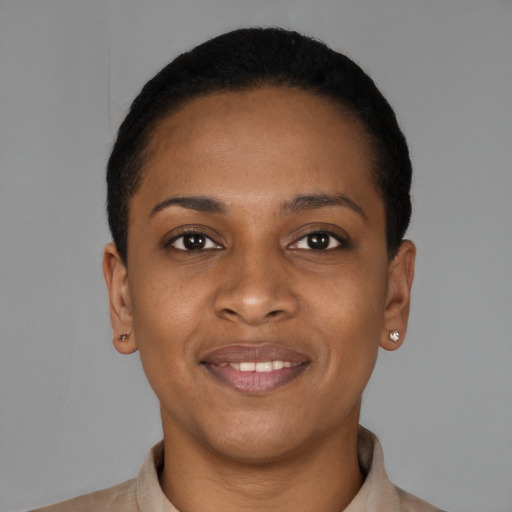 Joyful black young-adult female with short  black hair and brown eyes