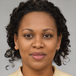 Joyful black adult female with medium  brown hair and brown eyes