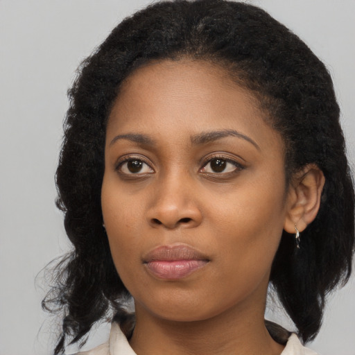 Joyful black young-adult female with medium  brown hair and brown eyes