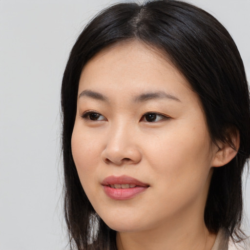 Joyful asian young-adult female with long  black hair and brown eyes