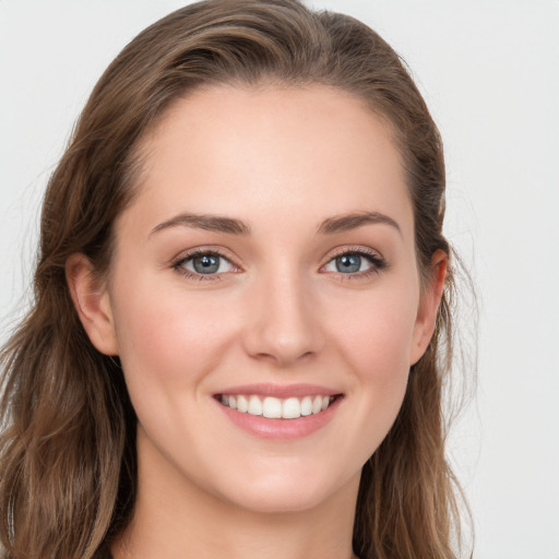 Joyful white young-adult female with long  brown hair and blue eyes