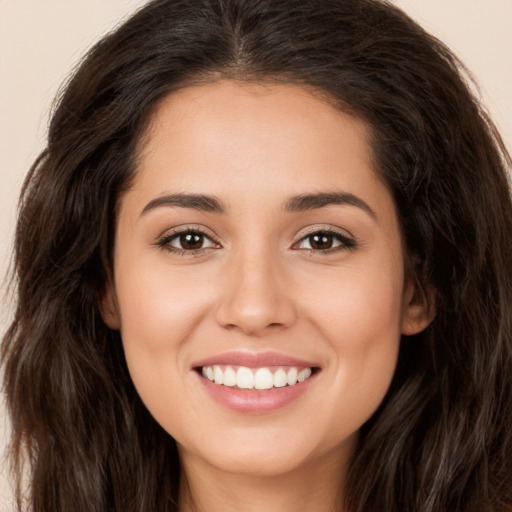 Joyful white young-adult female with long  brown hair and brown eyes