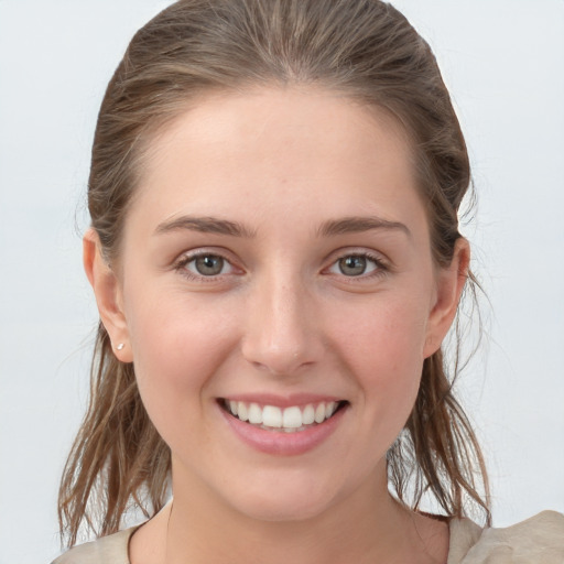 Joyful white young-adult female with medium  brown hair and grey eyes