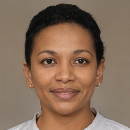 Joyful black young-adult female with short  black hair and brown eyes