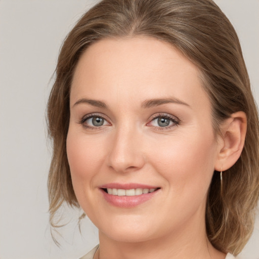 Joyful white young-adult female with medium  brown hair and grey eyes