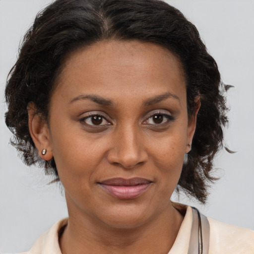 Joyful black adult female with medium  brown hair and brown eyes