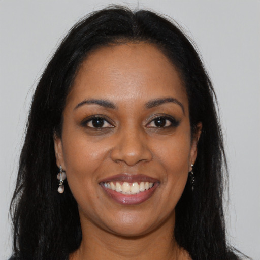 Joyful black young-adult female with long  brown hair and brown eyes