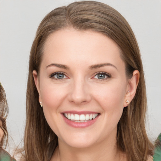 Joyful white young-adult female with long  brown hair and blue eyes