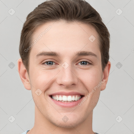 Joyful white young-adult male with short  brown hair and grey eyes