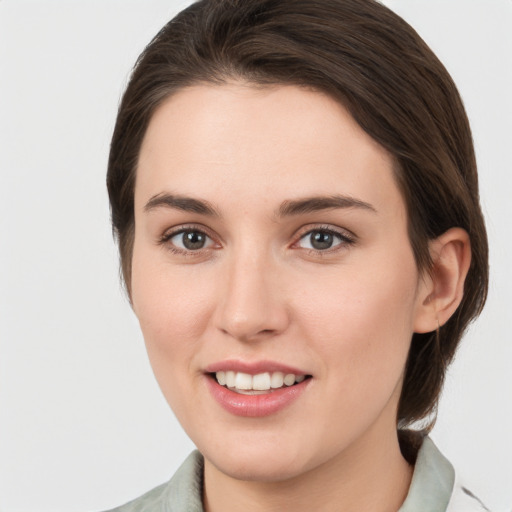 Joyful white young-adult female with medium  brown hair and grey eyes