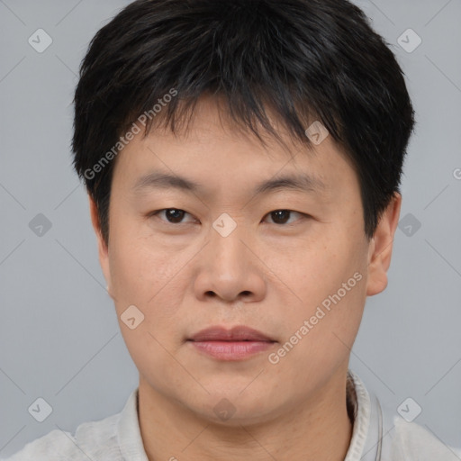 Joyful asian young-adult male with short  brown hair and brown eyes