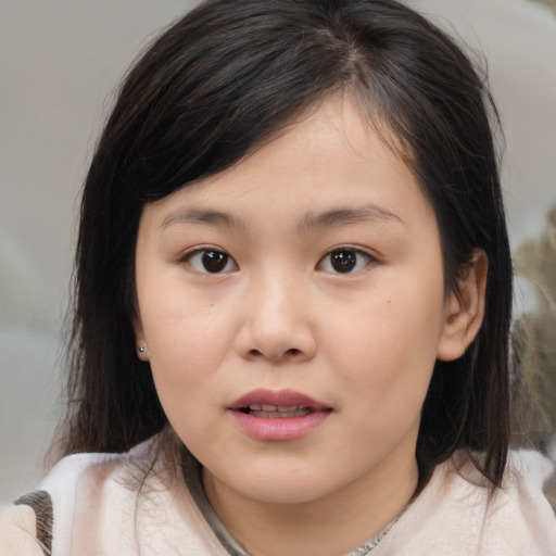 Joyful asian child female with medium  brown hair and brown eyes