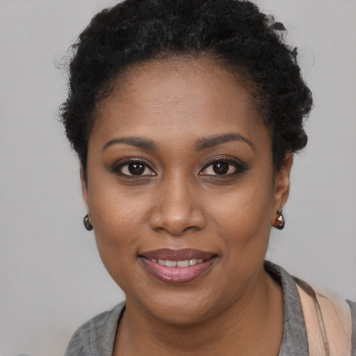 Joyful black young-adult female with short  brown hair and brown eyes