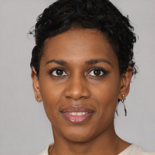 Joyful black young-adult female with short  black hair and brown eyes