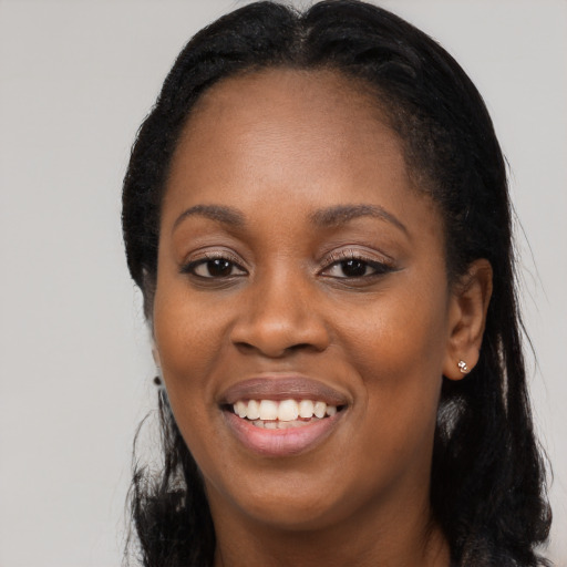 Joyful black young-adult female with long  black hair and brown eyes