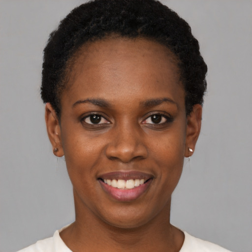 Joyful black young-adult female with short  black hair and brown eyes