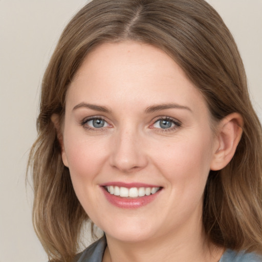 Joyful white young-adult female with medium  brown hair and blue eyes