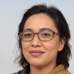 Joyful latino adult female with medium  brown hair and brown eyes