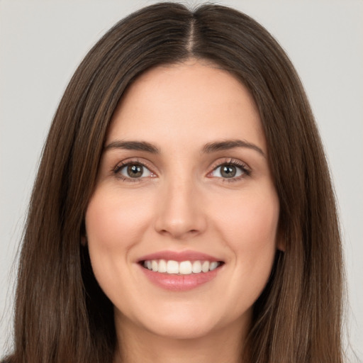 Joyful white young-adult female with long  brown hair and brown eyes