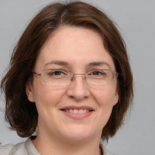 Joyful white adult female with medium  brown hair and grey eyes